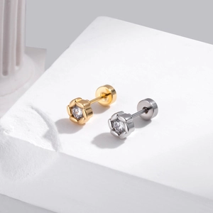 Détail de boucles d'oreilles fleur or et argent avec zircon sur socle en pierre