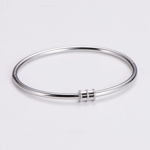 Detail of silver stainless steel bangle with minimalist circular centerpiece design