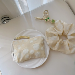 Détail d'une mini pochette en coton style peinture à l'huile avec chouchou et pince tulipe