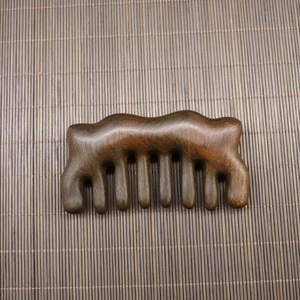 Macro view of polished dark sandalwood massage comb teeth on a bamboo mat background