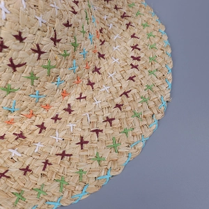 Bohemian straw sun hat with colorful cross-stitch embroidery and blue stitched edge