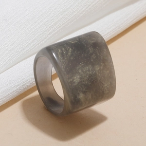 Detail shot of a dark grey resin square ring with gold glitter flakes and a smooth finish
