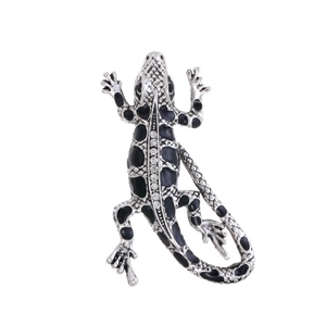 Detail of silver gecko brooch featuring black enamel spots and sparkling rhinestones