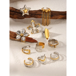 Artistic display of gold and silver steel rings and jewelry on wood branch decor
