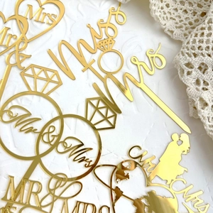 Golden mirror acrylic Mr & Mrs wedding cake toppers featuring romantic heart and ring designs