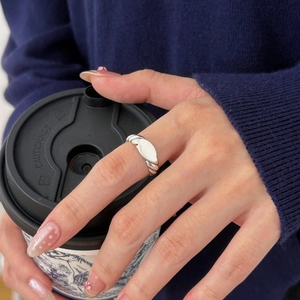 Detail of 925 sterling silver twisted rope ring with oval plate on model's finger