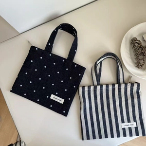 Detailed view of mini canvas handbags with polka dot and striped patterns for daily use