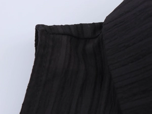 Vue macro de la texture du tissu côtelé noir et des coutures sur la robe sans manches