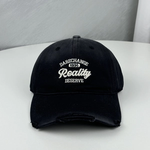 Distressed black baseball cap featuring white Reality embroidery and torn brim details