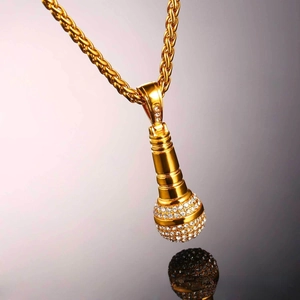 Macro shot of hip hop microphone pendant with pavé white zircons on a gold twisted chain