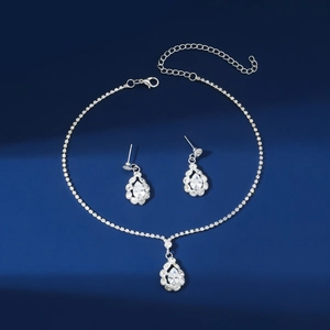 Elegant silver teardrop rhinestone necklace and earrings jewelry set on blue background