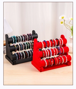 Three-tier velvet jewelry display stand for bracelets and watches on wooden table
