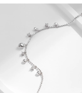 Detailed view of silver beaded bracelet with heart charms and cubic zirconia accents