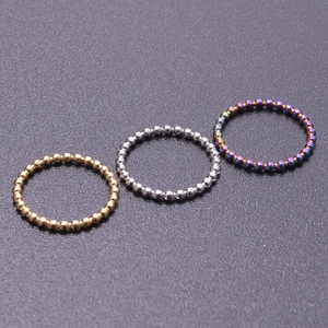 Three beaded stainless steel rings in gold, silver, and iridescent finishes in detail