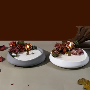 Detalle de velas decorativas encendidas con capullos de rosa y mecha de madera en cuencos