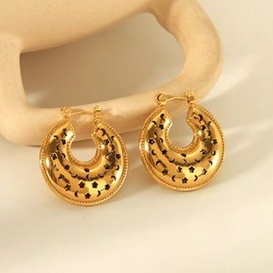 Golden heart-shaped hoop earrings with hollow moon and star patterns on white stands