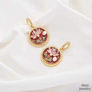 Macro detail of hand-painted floral pendants with enamel and pearl on white silk fabric