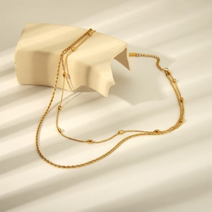 Double-layered gold twist rope chain necklace featuring a small cylindrical pendant charm