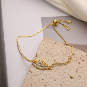Detailed close-up of adjustable golden evil eye bracelet with blue and white zircons