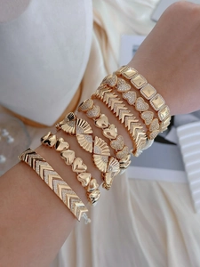 Stapel boheemse vergulde armbanden met hart- en geometrische details om de pols