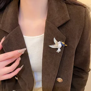 Elegant dove brooch with white enamel, zircon wings, and gold olive branch on suit lapel