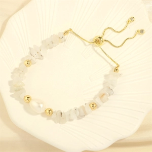 Detailed shot of an adjustable baroque pearl bracelet with colorful stone chips on a tray