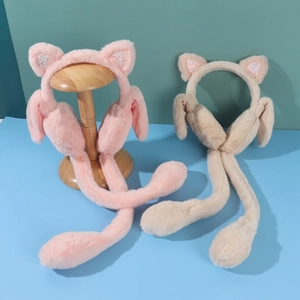 Detail of plush cat ear earmuffs in pink and beige with glitter lining and soft texture