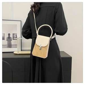 Detail of beige and camel crossbody bag featuring a metal clasp and leather texture