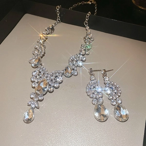 Macro view of teardrop rhinestone necklace and earrings set with silver finish sparkle