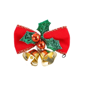 Detail of a red velvet bow with holly leaves and golden bells for Christmas decor