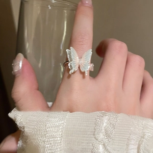 Detail of zircon butterfly open ring on index finger with white pearlescent wings