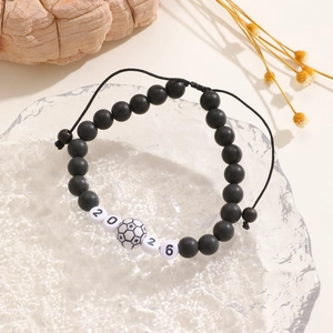 Detail of adjustable 2026 soccer bead bracelet with woven black cord and football charm