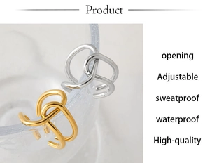 Detail of adjustable crisscross gold and silver rings on a clear glass edge
