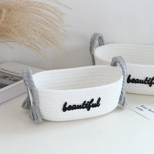 Detail showing white cotton rope basket with gray handles and beautiful embroidery