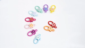 Flat lay of ten colorful flower shaped alloy spring ring clasps for DIY jewelry making