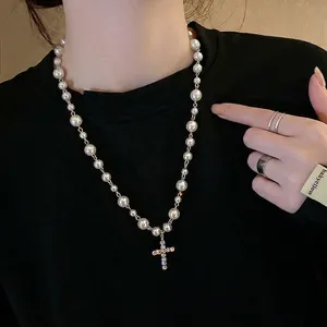 Collier de perles élégant avec un pendentif en forme de croix serti de strass