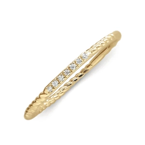 Detail of twisted gold ring band with seven inlaid white crystals on white background