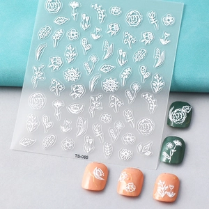 Detailed macro view of white 5D embossed nail stickers featuring rose and leaf patterns
