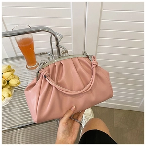 Détail d'un sac à main plissé rose avec fermoir argenté et bandoulière chaîne