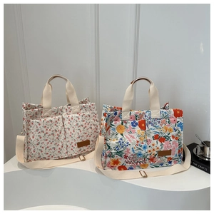 Floral canvas tote bags with beige straps and adjustable shoulder handle in warm white