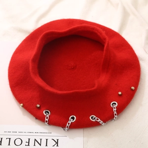 Red wool beret hat with hip-hop style silver chain and gold buckle on kinfolk book