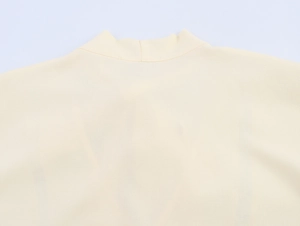 Detailed close-up of the elegant lace neckline and tie detail on this beige cotton linen shirt