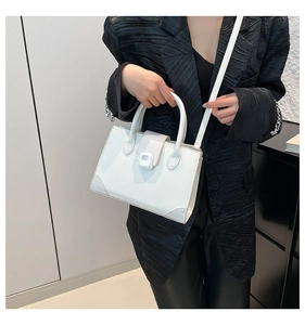 Elegante borsa a mano bianca in ecopelle con motivo a coccodrillo indossata da modella