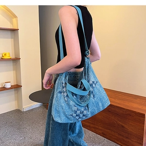 Detailed view of casual blue denim tote bag featuring a stitched star and wide strap