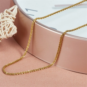Gros plan d'un collier en acier inoxydable doré avec une texture de chaîne raffinée.