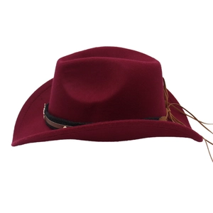 Dettaglio di cappello da cowboy bordeaux in feltro con fibbia metallica e frange marroni