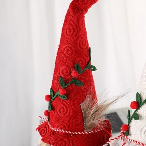 Handgefertigte Weihnachtswichtel-Puppe mit roter Strickmütze und grünem Blattornament
