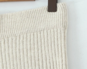 Detailaufnahme des beigen Rippstrickgewebes mit Fokus auf Textur und feiner Naht