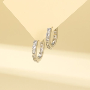Macro shot of silver geometric hoop earrings with sparkling square cubic zirconia studs