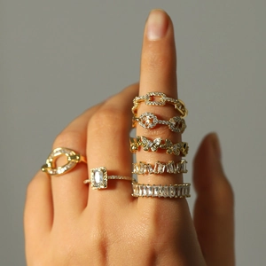 Gros plan de bagues en cuivre doré avec motifs papillon et chaîne sertis de zircon